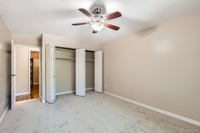 350 S Clinton St Unit 9B, Denver, CO 80247 - unfurnished bedroom featuring carpet floors, multiple closets, a textured ceiling, and a ceiling fan