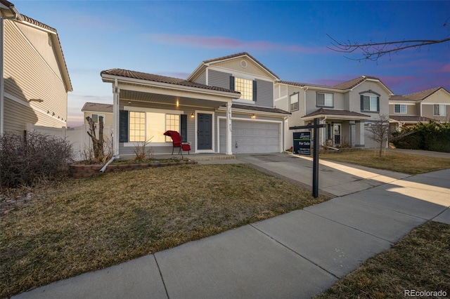 traditional-style home with concrete driveway, a tiled roof, a garage, and a front yard