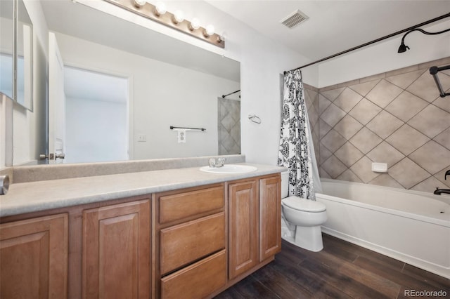 bathroom with visible vents, toilet, shower / bath combo, wood finished floors, and vanity