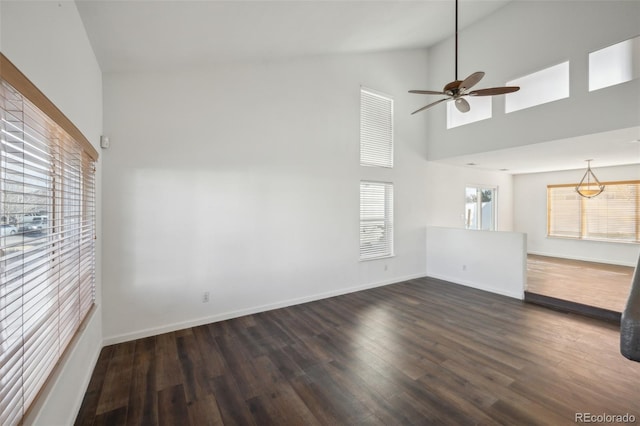 unfurnished living room with a ceiling fan, baseboards, dark wood-style flooring, and high vaulted ceiling