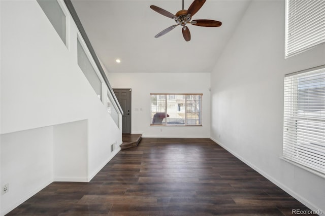 unfurnished living room with visible vents, high vaulted ceiling, a ceiling fan, wood finished floors, and baseboards