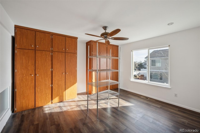 unfurnished bedroom with visible vents, dark wood finished floors, a closet, baseboards, and ceiling fan