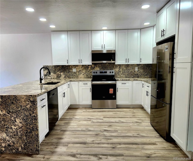 16800 E Bails Pl, Aurora, CO 80017 - kitchen featuring stainless steel appliances, a peninsula, light wood-type flooring, white cabinetry, and recessed lighting