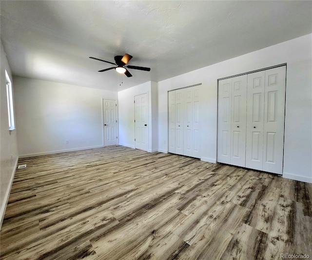 16800 E Bails Pl, Aurora, CO 80017 - unfurnished bedroom with wood finished floors, multiple closets, and a ceiling fan