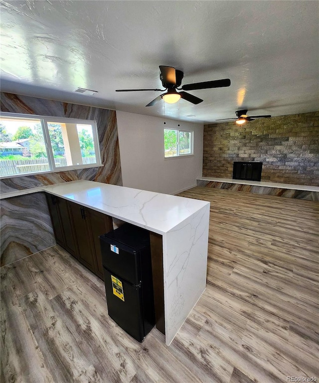 16800 E Bails Pl, Aurora, CO 80017 - kitchen with ceiling fan, light wood-type flooring, light stone countertops, open floor plan, and a peninsula