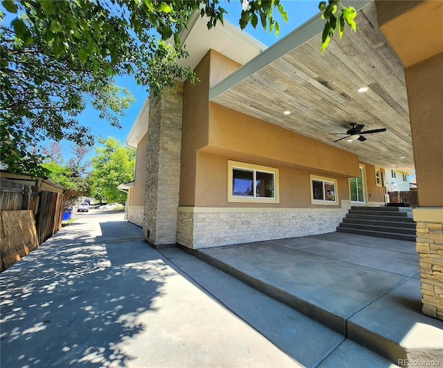 16800 E Bails Pl, Aurora, CO 80017 - view of home's exterior featuring stone siding, ceiling fan, stucco siding, and a patio