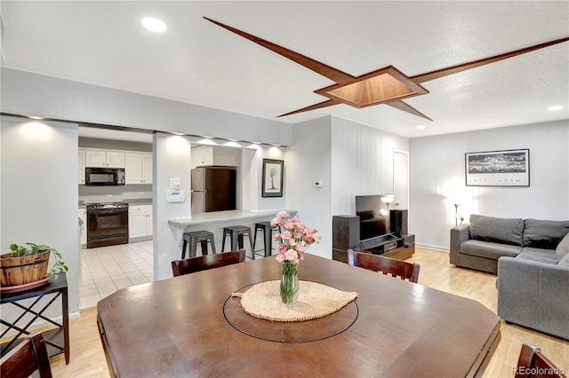 dining area featuring a textured ceiling and light hardwood / wood-style floors