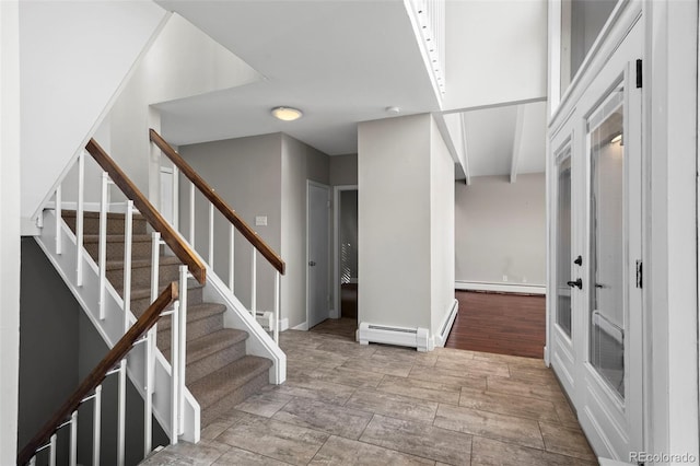 foyer entrance with a baseboard heating unit, baseboards, baseboard heating, and stairway