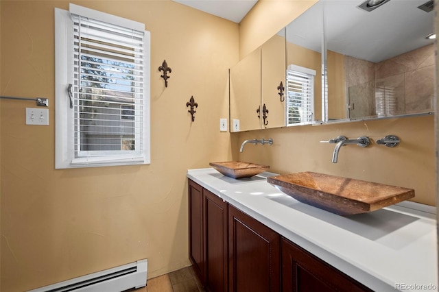 full bathroom featuring a sink, a baseboard radiator, double vanity, and a shower stall