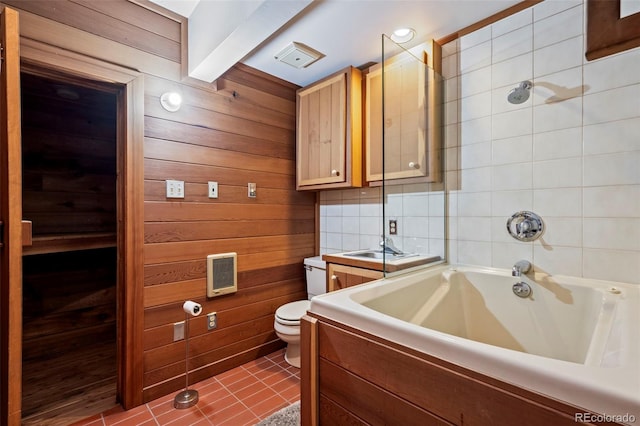 bathroom with tile patterned floors, wood walls, toilet, and bathing tub / shower combination