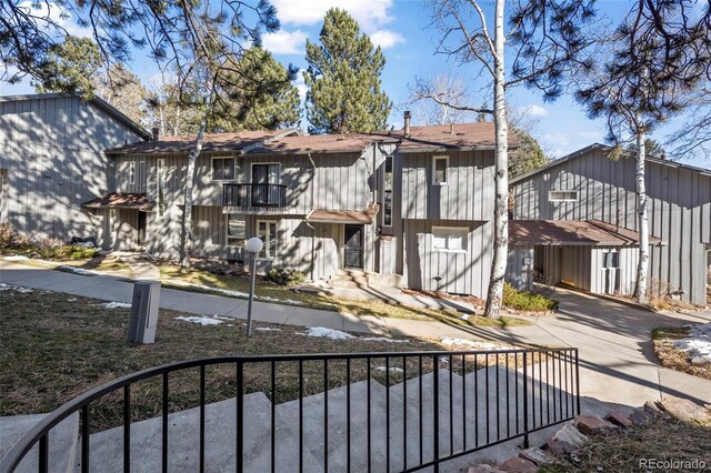 back of house featuring a balcony and a fenced front yard