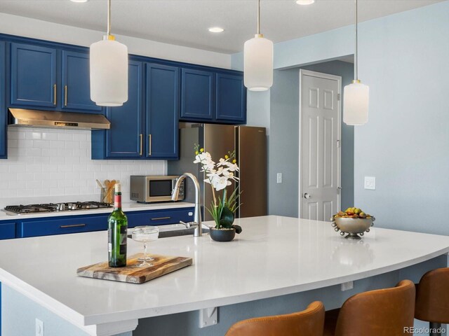 800 Boulder Peak Ave, Erie, CO 80516 - kitchen with blue cabinets, stainless steel appliances, under cabinet range hood, a kitchen bar, and recessed lighting