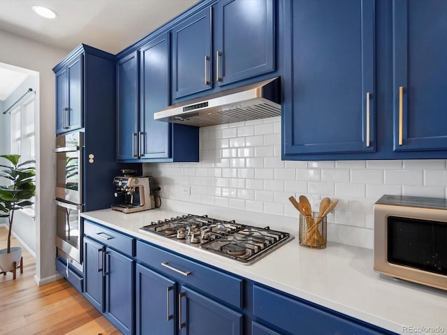 800 Boulder Peak Ave, Erie, CO 80516 - kitchen with blue cabinets, stainless steel appliances, under cabinet range hood, and recessed lighting