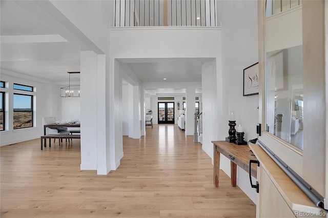 entrance foyer with a high ceiling, a chandelier, and light wood-type flooring