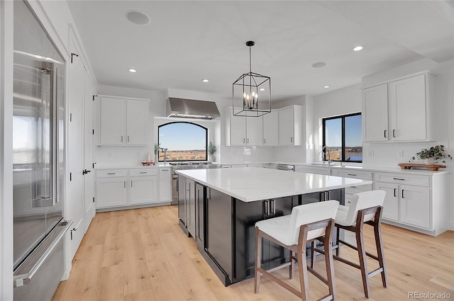 8700 Lost Lake Dr, Franktown, CO 80116 - kitchen featuring white cabinets, built in refrigerator, a kitchen island, wall chimney exhaust hood, and decorative backsplash