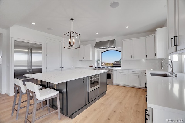 8700 Lost Lake Dr, Franktown, CO 80116 - kitchen with white cabinets, a center island, a sink, high end appliances, and wall chimney range hood