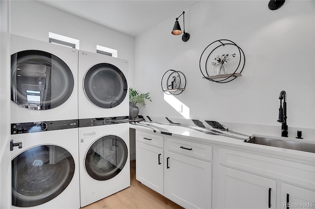 8700 Lost Lake Dr, Franktown, CO 80116 - washroom featuring light wood finished floors, stacked washer and dryer, a sink, and cabinet space