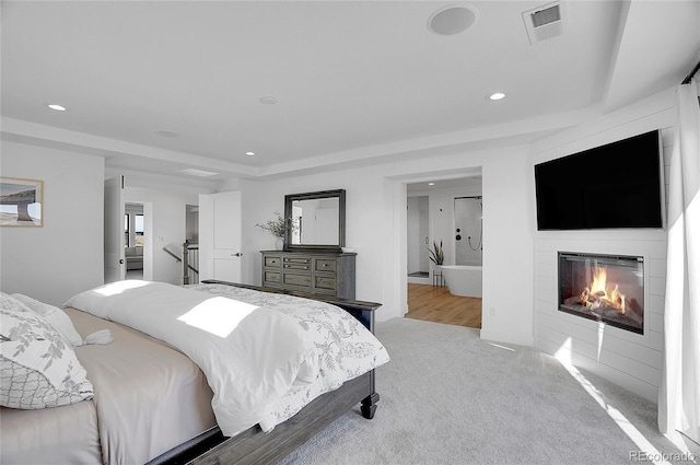 8700 Lost Lake Dr, Franktown, CO 80116 - bedroom with a glass covered fireplace, visible vents, recessed lighting, ensuite bath, and carpet floors
