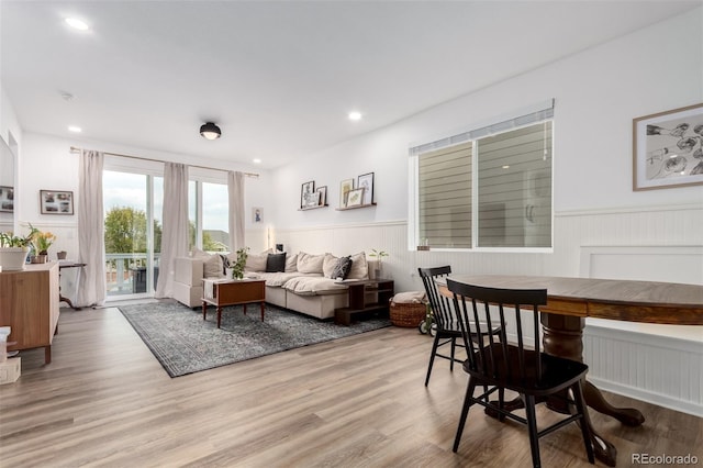living room featuring a wainscoted wall, light wood-style flooring, recessed lighting, and a decorative wall