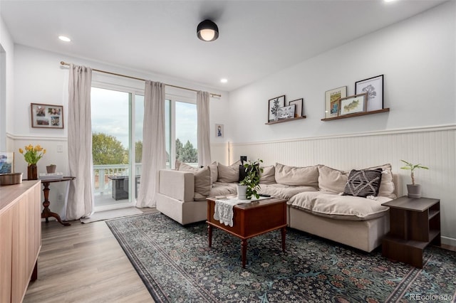 living area with a wainscoted wall, light wood-type flooring, and recessed lighting