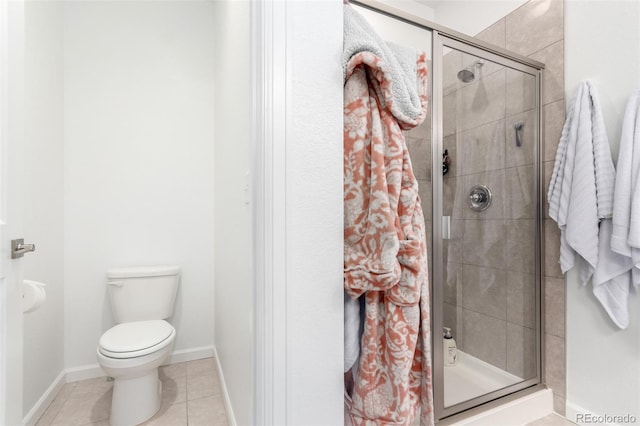 bathroom with a shower stall, tile patterned flooring, toilet, and baseboards