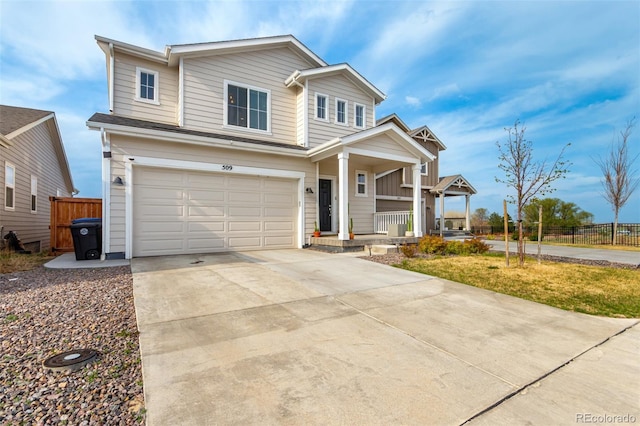 traditional home featuring covered porch, fence, an attached garage, and driveway