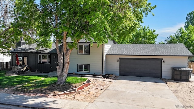 321 Stockton Ct, Gilcrest, CO 80623 - view of front facade featuring an attached garage, driveway, fence, and roof with shingles