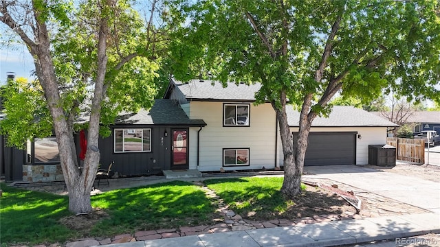 321 Stockton Ct, Gilcrest, CO 80623 - tri-level home with driveway, an attached garage, a shingled roof, and board and batten siding
