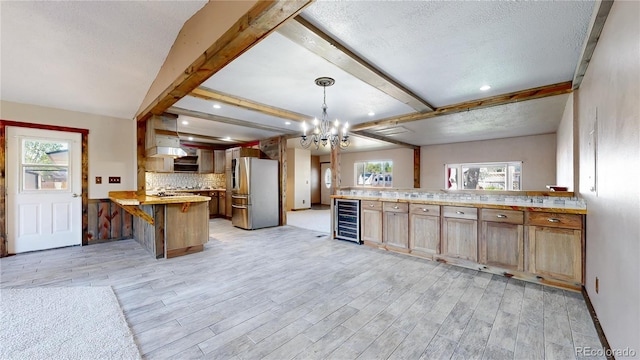 321 Stockton Ct, Gilcrest, CO 80623 - kitchen featuring stainless steel fridge, beverage cooler, a peninsula, light wood-type flooring, and a textured ceiling