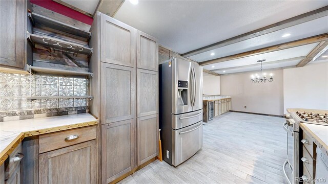 321 Stockton Ct, Gilcrest, CO 80623 - kitchen featuring stainless steel appliances, beam ceiling, light wood finished floors, a chandelier, and baseboards