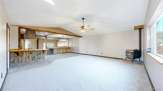 321 Stockton Ct, Gilcrest, CO 80623 - unfurnished living room featuring light carpet, ceiling fan, a wood stove, beverage cooler, and baseboards