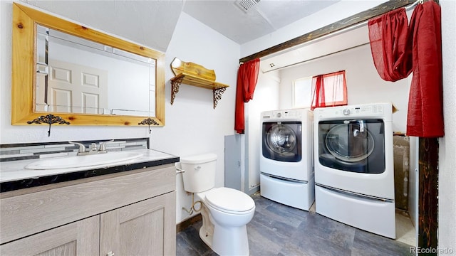 321 Stockton Ct, Gilcrest, CO 80623 - bathroom featuring washer and dryer, toilet, and vanity