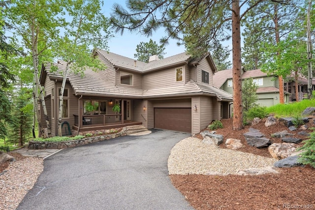 29962 Troutdale Ridge Rd, Evergreen, CO 80439 - view of front of property with driveway, a garage, a porch, and a chimney