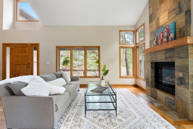 29962 Troutdale Ridge Rd, Evergreen, CO 80439 - living room featuring high vaulted ceiling, wood finished floors, a tile fireplace, and baseboards