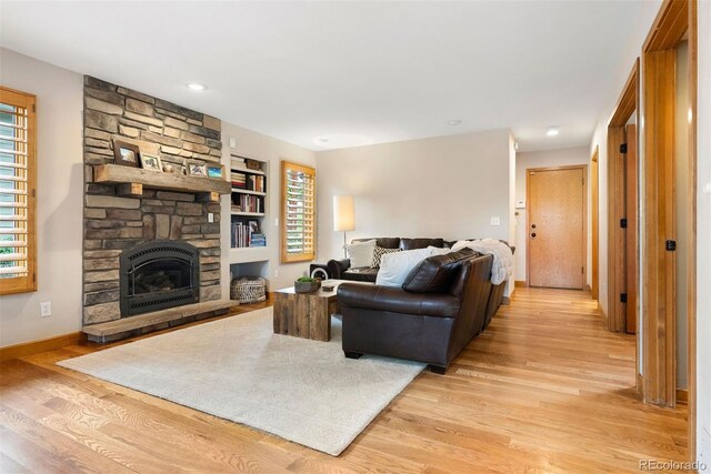 29962 Troutdale Ridge Rd, Evergreen, CO 80439 - living area with light wood-type flooring, a fireplace, built in shelves, and baseboards