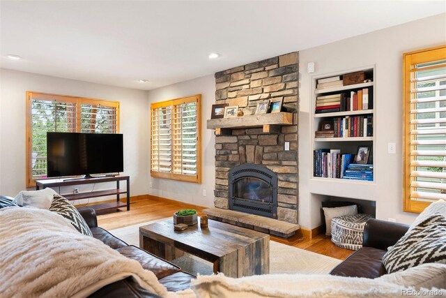 29962 Troutdale Ridge Rd, Evergreen, CO 80439 - living area with wood finished floors, a stone fireplace, baseboards, and recessed lighting