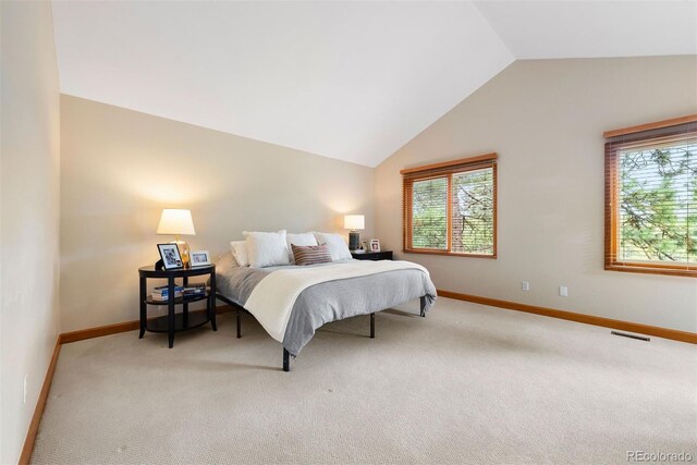 29962 Troutdale Ridge Rd, Evergreen, CO 80439 - bedroom with multiple windows, light carpet, baseboards, and vaulted ceiling