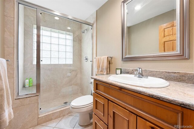 29962 Troutdale Ridge Rd, Evergreen, CO 80439 - full bathroom with toilet, a stall shower, vanity, and tile patterned flooring