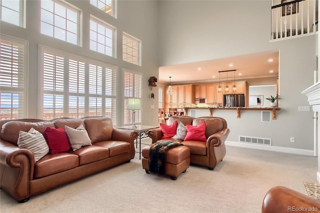 living room with crown molding, light colored carpet, and a high ceiling