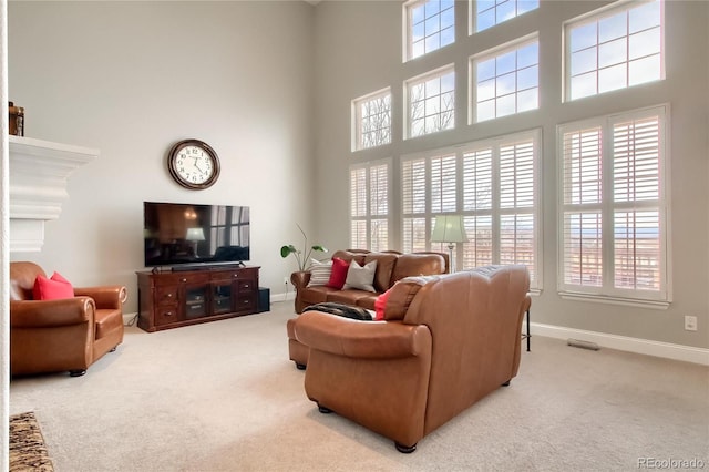 carpeted living room featuring a towering ceiling