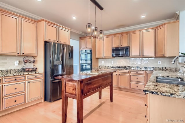 kitchen with sink, light stone counters, crown molding, decorative light fixtures, and stainless steel appliances