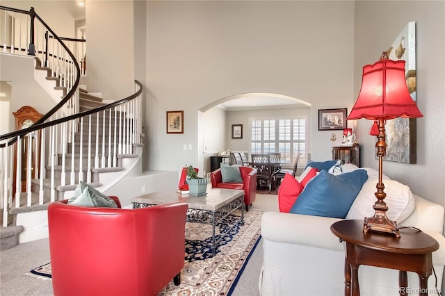 carpeted living room with a high ceiling