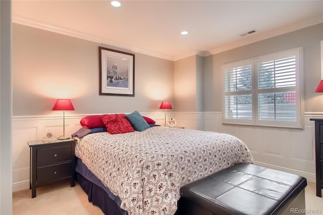 bedroom with ornamental molding and light colored carpet