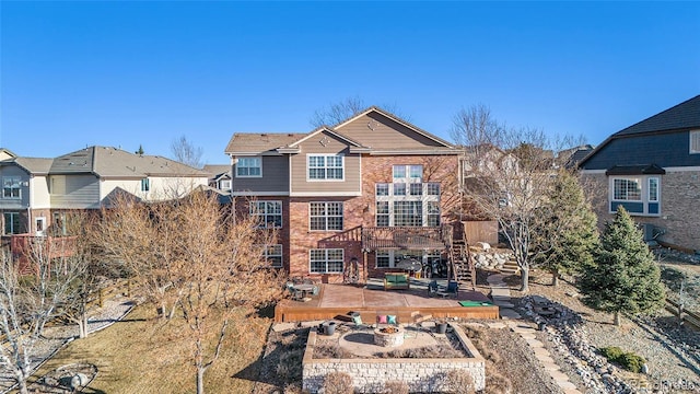 rear view of house featuring a patio and a fire pit