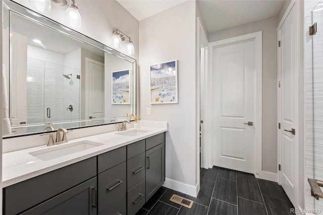 bathroom featuring a shower with shower door and vanity