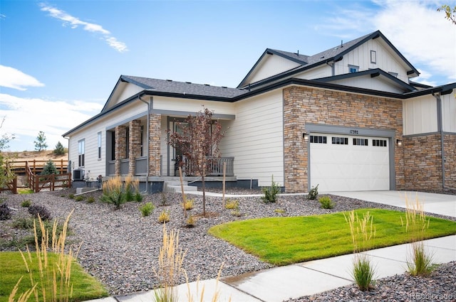 view of front of home with central AC unit, a garage, and covered porch