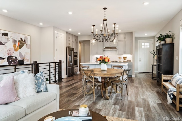 dining area with an inviting chandelier and dark hardwood / wood-style floors