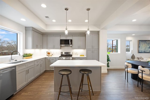 8406 W 52nd Ave, Arvada, CO 80002 - kitchen with stainless steel appliances, gray cabinets, a center island, backsplash, and recessed lighting