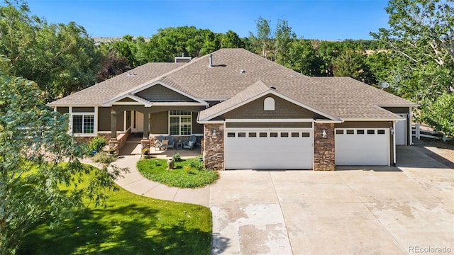 view of front of property featuring a garage, covered porch, and a front lawn