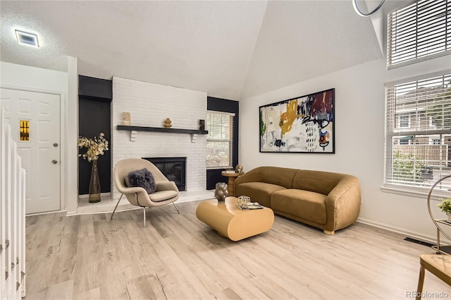 14129 E Dickinson Dr Unit D, Aurora, CO 80014 - living area featuring wood finished floors, a textured ceiling, a fireplace, and vaulted ceiling